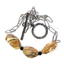 Load image into Gallery viewer, Necklace with stone-like beads and a large circular pendant on a white background