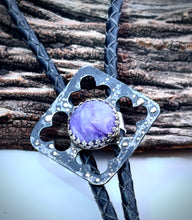 Load image into Gallery viewer, Bolo tie with charoite stone with steel and silver on braided leather strap, placed on wooden surface.