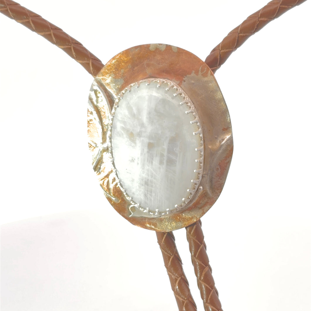 Bolo tie with gold and white stone on a white background
