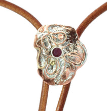 Load image into Gallery viewer, Close-up of a decorative metal bolo tie with a ruby gemstone on a white background