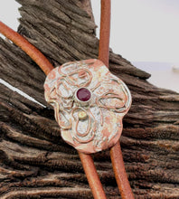 Load image into Gallery viewer, Decorative leather strap with a metal buckle featuring a ruby gemstone on a wooden background.
