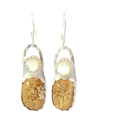 Pair of earrings with goldstone stones on a white background
