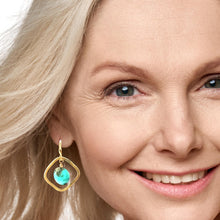 Load image into Gallery viewer, Close-up of a woman wearing a gold earring with a turquoise gemstone.