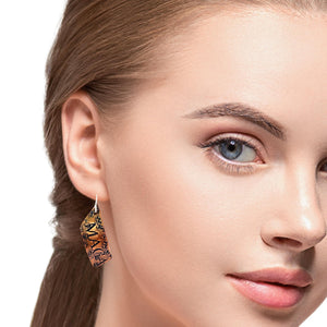 Close-up of a woman wearing an earring with a neutral background