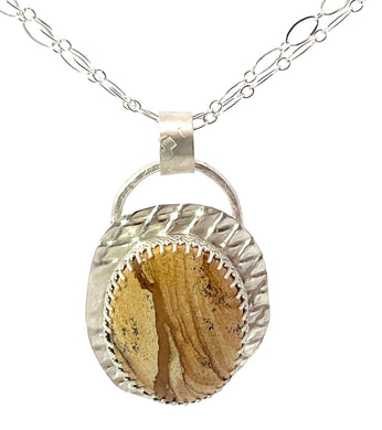 Necklace with a round pendant featuring a natural stone design on a white background