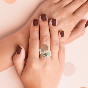 Hand wearing a size 9 sterling silver ring with a faceted rose quartz gem, showcasing its unique design and pink hue.