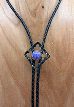 Load image into Gallery viewer, Black braided bolo tie with a charoite stone on a wooden surface