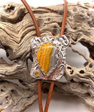 Load image into Gallery viewer, Silver and bumblebee jasper bolo tie on brown cord against a textured stone background