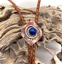 Load image into Gallery viewer, Bolo tie withl apis stone and brown leather cord on a wooden background