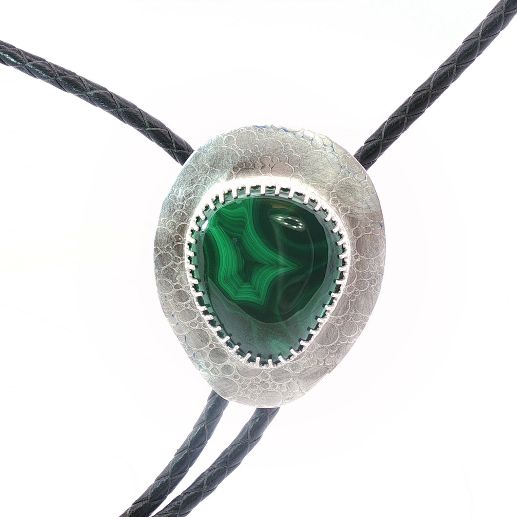Bolo tie with green stone and silver metal on a white background