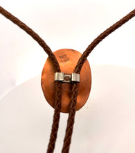 Load image into Gallery viewer, Close-up of a bolo tie with a copper clasp on a white background