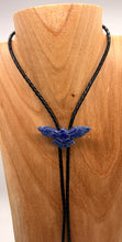 Load image into Gallery viewer, Blue lapis gemstone bolo tie on a black cord displayed on a wooden mannequin.