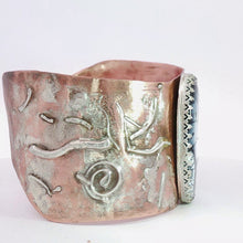 Load image into Gallery viewer, A handmade hammered metal cuff bracelet in copper and silver shown from side. 