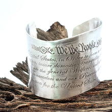 Load image into Gallery viewer, Silver cuff bracelet with engraved text on a wooden surface