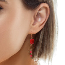 Load image into Gallery viewer, A close-up of a model's ear wearing a dangling earring with a  red coral  and copper links