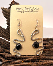 Load image into Gallery viewer, Pair of silver and black onyx earrings on a display card with 'Wear a Work of Art' text, placed on wooden surface.