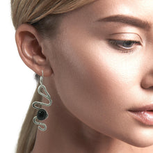 Load image into Gallery viewer, Close-up of a woman wearing a silver earring with a black onyx gemstone 