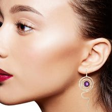 Load image into Gallery viewer, Close-up of a woman wearing a silver earring with a purple gemstone.