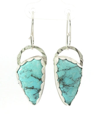 Turquoise arrowhead earrings with silver frames on a white background