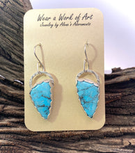 Load image into Gallery viewer, Turquoise arrowhead-shaped earrings on a display card with wooden background