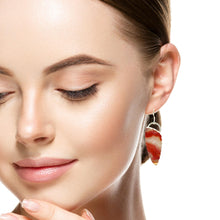 Load image into Gallery viewer, Close-up of a woman wearing a silver earring with red stones on a white background