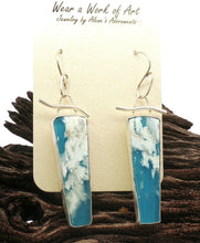 Load image into Gallery viewer, A pair of sterling silver drop earrings with vertical rectangular plume agate and blue gems , displayed on a cream card over dark wood.