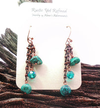 Load image into Gallery viewer, A pair of handmade dangle earrings displayed on a white jewelry card. The earrings feature copper hains, turquoise- beads