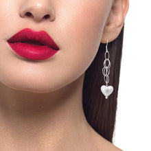 Load image into Gallery viewer, Close-up of a woman wearing silver earrings with a heart charm, 