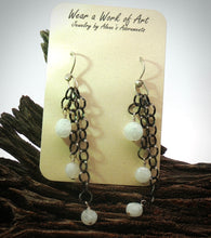 Load image into Gallery viewer, A pair of dangle earrings displayed on a cream card that reads 'Wear a Work of Art Jewelry .' The earrings have dark oxidized metal chains with small faceted moonstone beads
