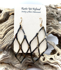 gold and steel earrings in natural setting