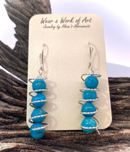 Load image into Gallery viewer, Sacred spiral turquoise earrings on display, featuring vibrant turquoise beads wrapped in sterling silver, 2 1/4&quot; long.