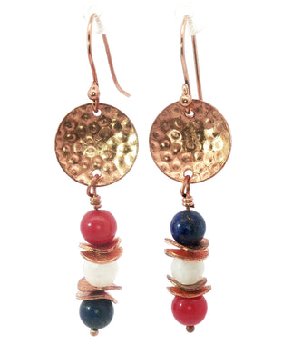 Pair of earrings with gold discs and colorful beads on a white background