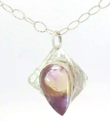 Necklace with a teardrop-shaped purple gemstone pendant on a white background