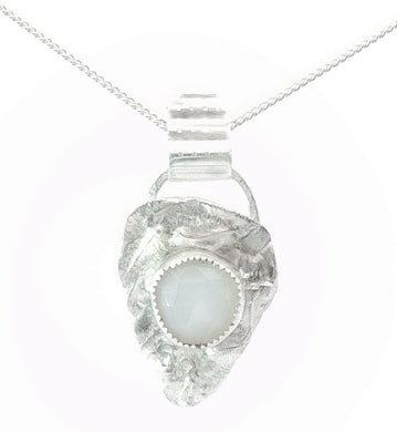 Silver pendant with a white stone on a white background
