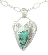 Load image into Gallery viewer, A sterling silver pendant necklace featuring a textured, heart-shaped silver frame with engraved floral details and a central triangular turquoise stone, suspended from a silver chain on a white background.