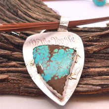 Load image into Gallery viewer, Turquoise stone pendant with 'We the People' engraving on a wooden background