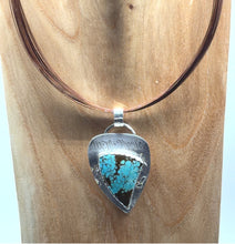 Load image into Gallery viewer, Turquoise pendant on a leather cord against a wooden background