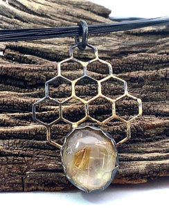 golden steel pendant in natural setting