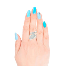 Load image into Gallery viewer, Hand wearing a silver ring with a crescent moon design on a white background