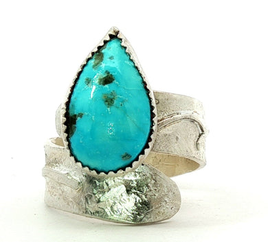 Silver ring with a large turquoise stone on a white background