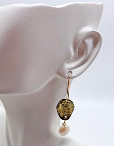 golden steel earring shown on ear