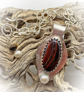 tiger iron and pearl pendant in natural setting