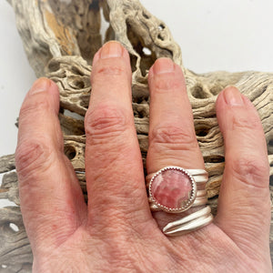 rhodochrosite ring shown on hand